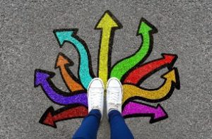 photo of someone standing on top of coloured arrows pointing in many directions